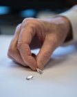 BIJOUTERIE – Gros plan d'une main touchant des diamants.