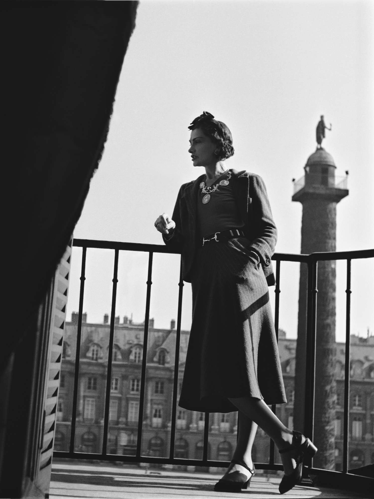 Photographie de Gabrielle Chanel au balcon de sa suite au Ritz Paris © Collection Schall Roger Schall