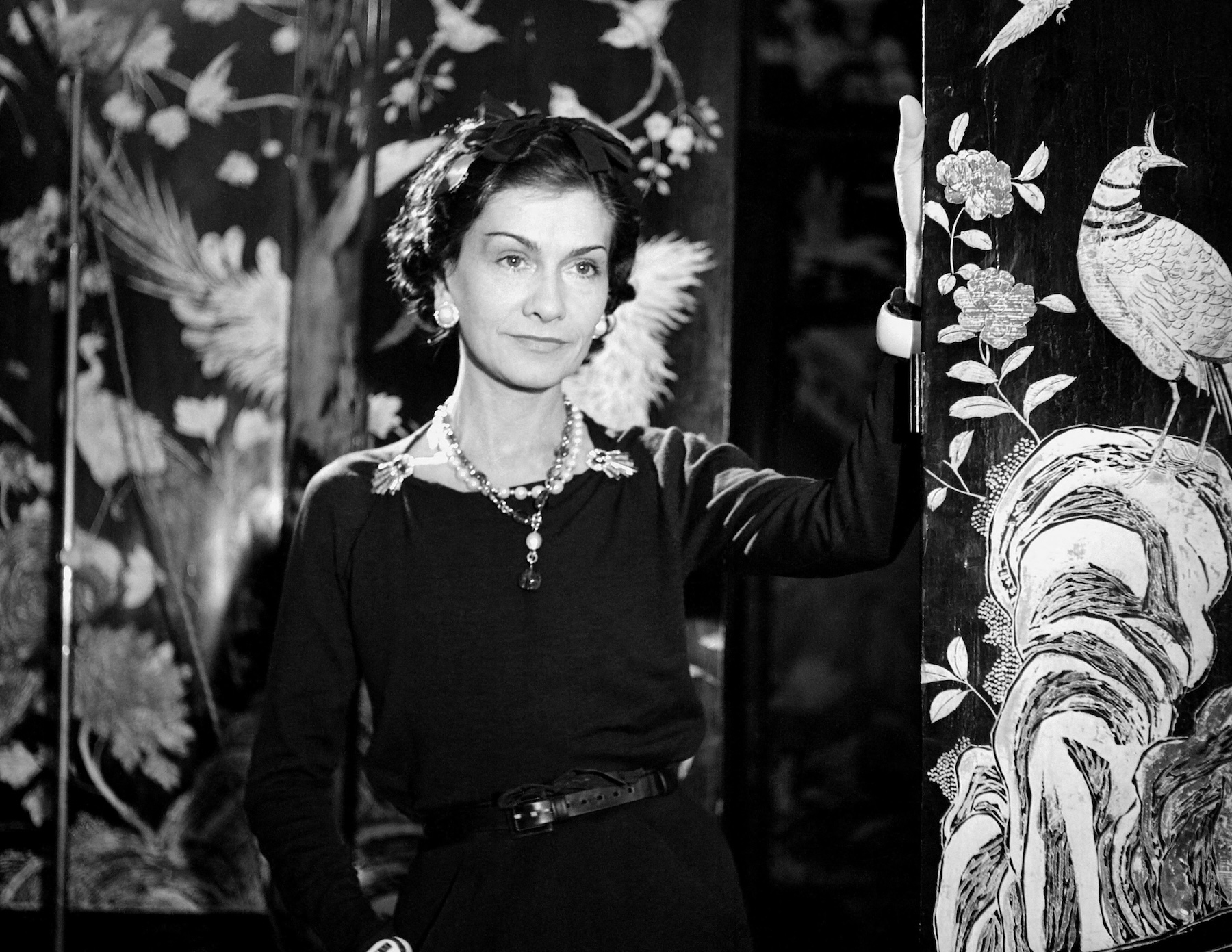 Gabrielle Chanel pose en tenue noire entre ses paravents Coromandel, 1937. Photographie © Boris Lipnitzki/Roger- Viollet. © Archives privées/All rights reserved. Courtesy of CHANEL