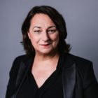 La parfumeuse Sophie Labbé en costume noir et rouge à lèvres rouge.