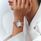 Un modèle porte la montre Big Bang One Click Joyful orange avec des saphirs oranges. ©Hublot