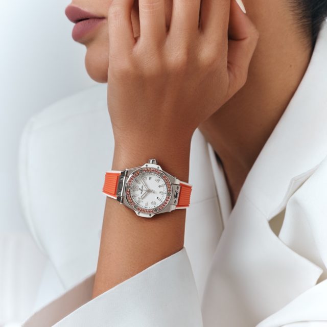 Un modèle porte la montre Big Bang One Click Joyful orange avec des saphirs oranges. ©Hublot
